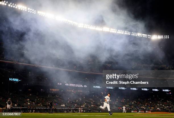 Ty France of the Seattle Mariners runs to first base as smoke clears from fireworks that fired after a home run by Mitch Haniger of the Seattle...