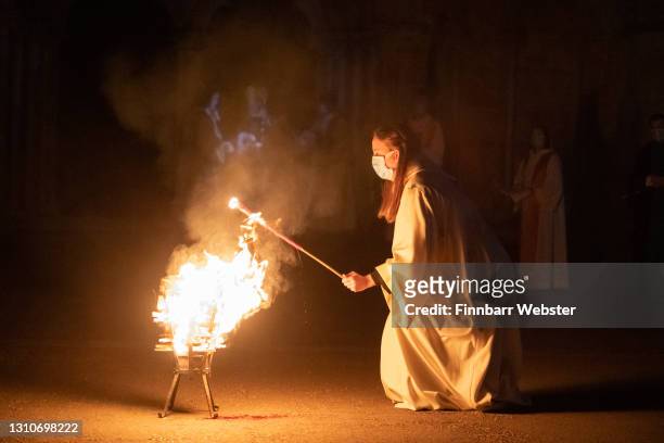 Fire in the brazier is used to light a wick for The Right Rev. Nicholas Holtam, Bishop of Salisbury, to light the Paschal candle with, at Salisbury...