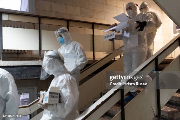 Mobile voting station staffers wearing protective suits walk towards the COVID-19 ward to collect votes from patients in the Kardzhali hospital on...