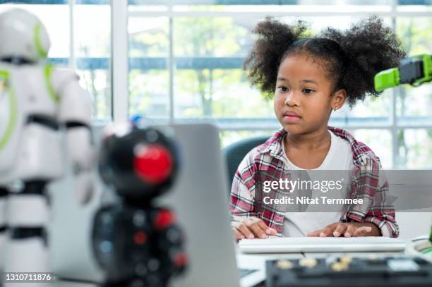 african american elementary schoolgirl proudly while using laptop in  technology classroom.  learning, education and technology concepts. - genius stock pictures, royalty-free photos & images