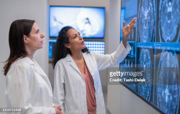 los médicos consultan sobre una resonancia magnética - radiologist fotografías e imágenes de stock