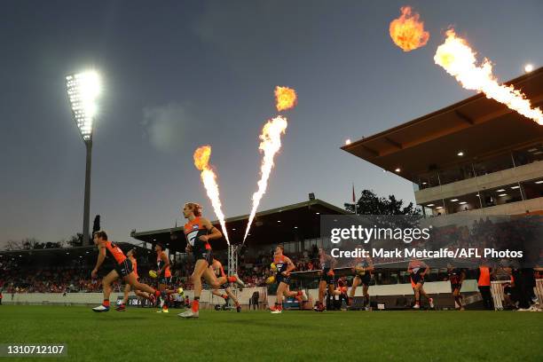 Giants run onto the field during the round 3 AFL match between the GWS Giants and the Melbourne Demons at Manuka Oval on April 04, 2021 in Canberra,...