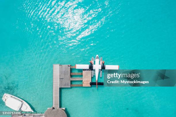 vista de drones del hidroavión atracado en el muelle del hotel - hidroavión fotografías e imágenes de stock