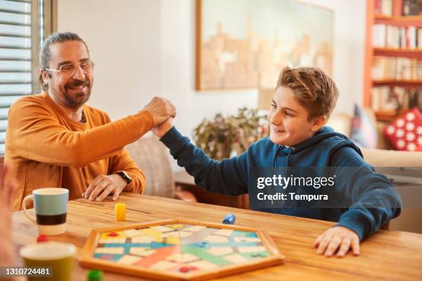 father and son happy after winning a board game match. - board game stock pictures, royalty-free photos & images