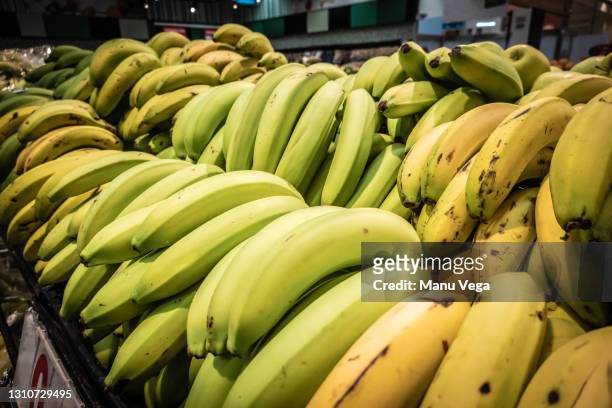 stack of bananas on a supermarket shelf. - banana plantation stock pictures, royalty-free photos & images