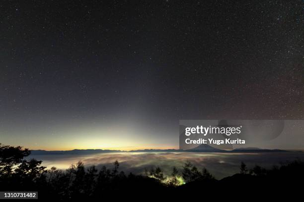 mt. fuji over a sea of clouds under a starry sky with the zodiacal light - zodiacal light stock pictures, royalty-free photos & images