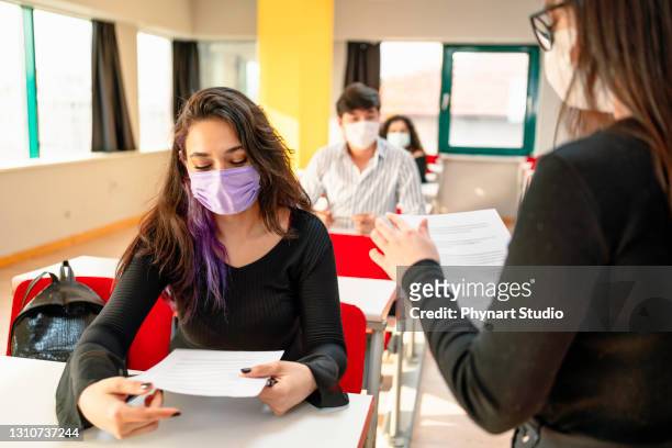 studenten im klassenzimmer tragen schutzmaske - exam hall stock-fotos und bilder