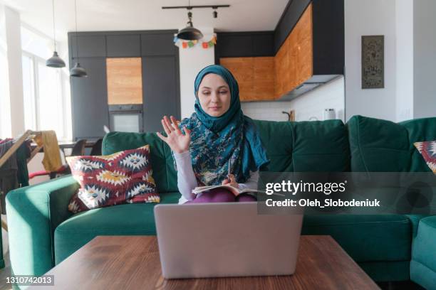 muslim woman talking on zoom - burka stock pictures, royalty-free photos & images