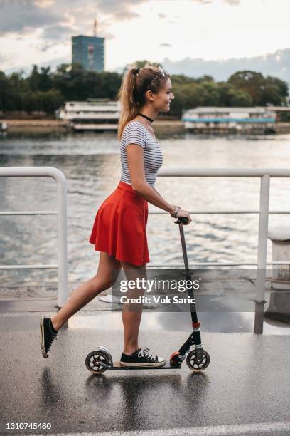 a young woman pushing a kick scooter - press brake stock pictures, royalty-free photos & images