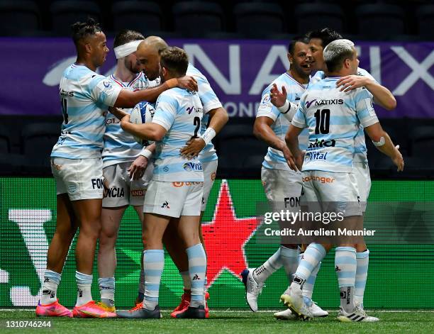Teddy Thomas of Racing 92 celebrates with teammates after scoring his team's sixth try during the Round of 16 Champions Cup match between Racing 92...