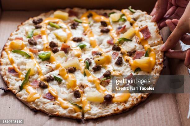 freshly delivered thin crust pizza in a pizza box - hawaiian pizza stock pictures, royalty-free photos & images