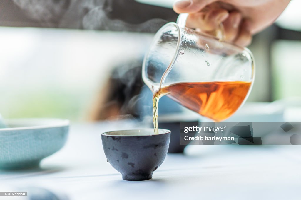 Close-up of human hands serving chinese tea
