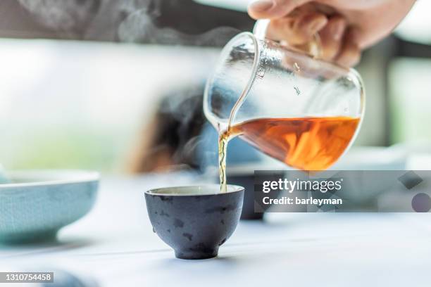 close-up of human hands serving chinese tea - kräutertee stock-fotos und bilder