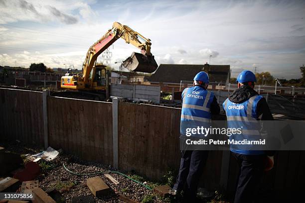 Bailiffs watch as a digger clears a plot at Dale Farm travellers camp on November 1, 2011 in Basildon, United Kingdom. Residents who live in the...