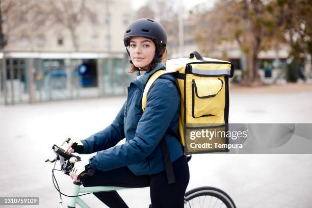 one home delivery female looking at camera. - bike messenger stock pictures, royalty-free photos & images