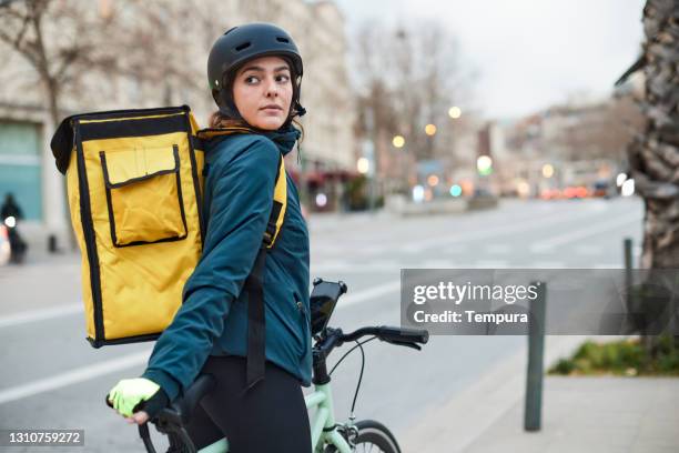 eine fahrradbotin in der stadt - fahrradkurier frau stock-fotos und bilder