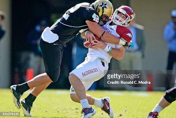 Quarterback Tyler Wilson of the Arkansas Razorbacks gets sacked by Tim Fugger of the Vanderbilt Commodores during a college football game at...