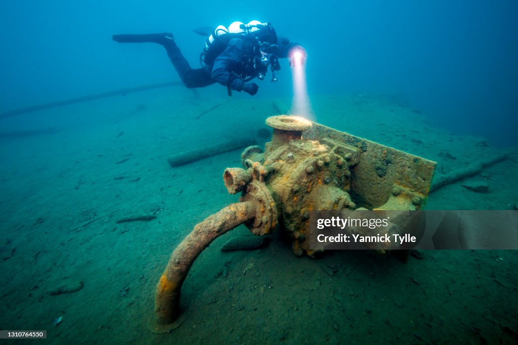 A scuba diver explores residues of open pit mining in a flooded mine