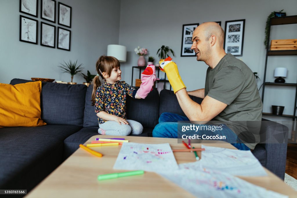 Vater spielt mit vierjähriger Tochter mit Puppen zu Hause