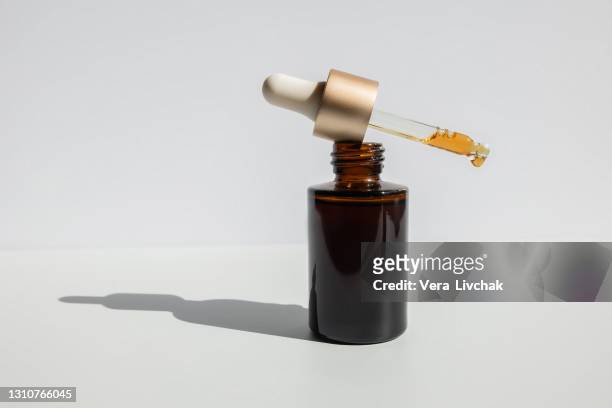 brown glass with a dropper. bottle mockup cosmetic oil dropper on a grey background and shadows. copy space - beauty cosmetic luxury studio background stock-fotos und bilder