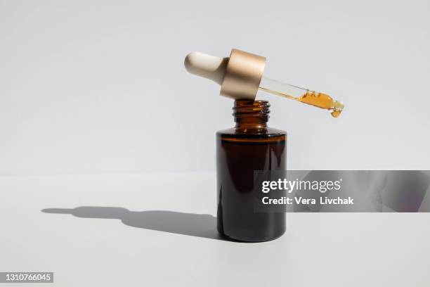 brown glass with a dropper. bottle mockup cosmetic oil dropper on a grey background and shadows. copy space - beauty cosmetic luxury studio background stock pictures, royalty-free photos & images