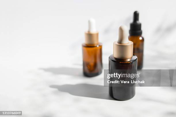 brown glass with a dropper. bottle mockup cosmetic oil dropper on a grey background and shadows. copy space - beauty cosmetic luxury studio background photos et images de collection