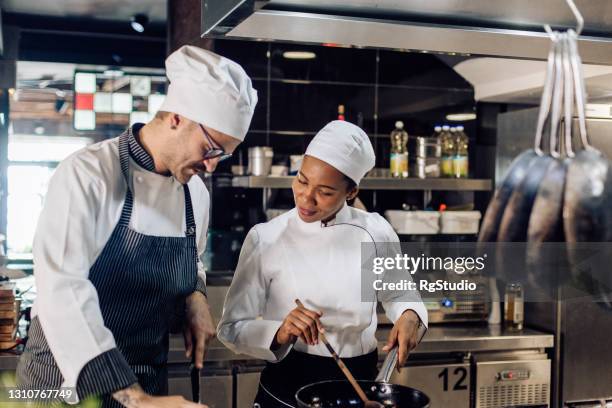 young female cook learning from the chef - restaurant staff stock pictures, royalty-free photos & images