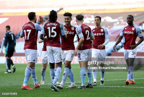 Ollie Watkins of Aston Villa celebrates with team mates Matty Cash and Bertrand Traore after scoring their side's third goal during the Premier...