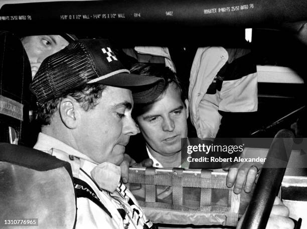 Driver Geoff Bodine talks with his crew chief Gary Nelson prior to the start of the 1986 Pepsi Firecracker 400 stock car race at Daytona...