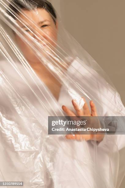 diversity woman stretcing plastic wrap - cellophane stock pictures, royalty-free photos & images