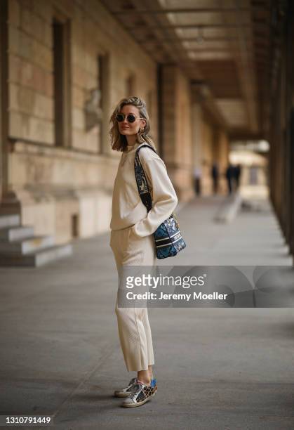 Mandy Bork wearing Linda Farrow shades, beige Zara two piece, blue Lady Dior bag and Golden Goose sneakers on April 01, 2021 in Berlin, Germany.