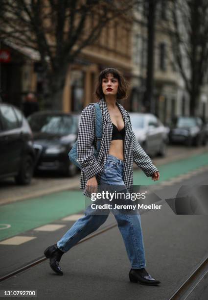 Lea Naumann wearing Chanel jeans bag and headband, Calvin Klein blue jeans, black Armed Angels crop top, vintage blazer and black Gestuz boots on...