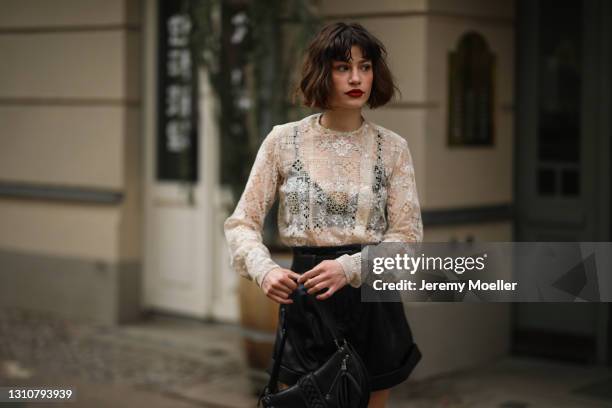 Lea Naumann wearing Dior linen fabric top, Self Portrait mini leather shorts and black vintage Dior leather bag on April 01, 2021 in Berlin, Germany.