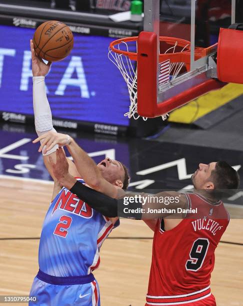 Blake Griffin of the Brooklyn Nets puts up a reverse against Nikola Vucevic of the Chicago Bulls at the United Center on April 04, 2021 in Chicago,...