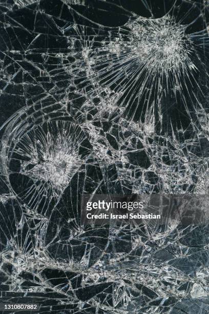 close-up view of a cell phone screen broken into a thousand pieces - broken smartphone fotografías e imágenes de stock