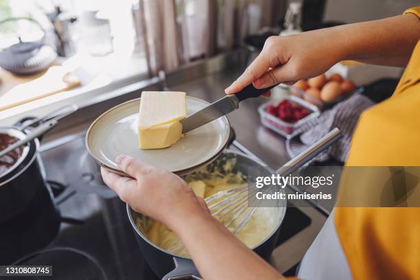 anonyme junge frau vorbereitung creme für einen kuchen - butter stock-fotos und bilder