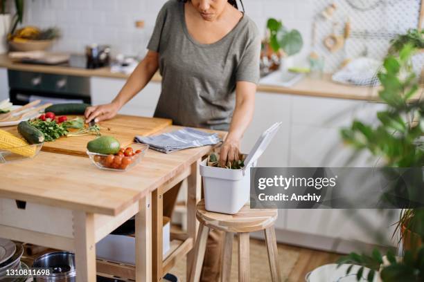 mujer poniendo residuos orgánicos en papelera de compost - avoids fotografías e imágenes de stock