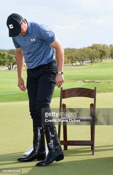 Jordan Spieth tries on cowboy boots after putting in to win during the final round of Valero Texas Open at TPC San Antonio Oaks Course on April 04,...