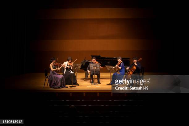 five musicians playing violin, viola, and cello at classical music concert - orquestra imagens e fotografias de stock