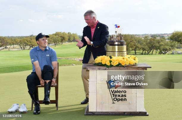 Jordan Spieth tries on cowboy boots after putting in to win as Chairman of the Tournament and Corporate Vice President of Marketing at Valero Eric...