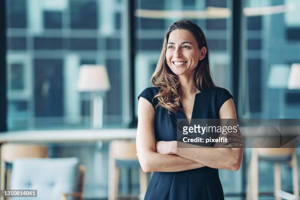 porträt einer geschäftsfrau, die in einem modernen büro steht - unternehmer stock-fotos und bilder