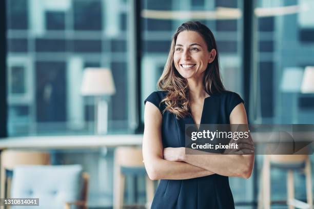 verticale d’une femme d’affaires restant dans un bureau moderne - vainqueur photos et images de collection