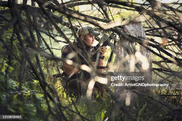 hidden man in camouflage hunting animals with snipe rifle. - pic hunter stock pictures, royalty-free photos & images