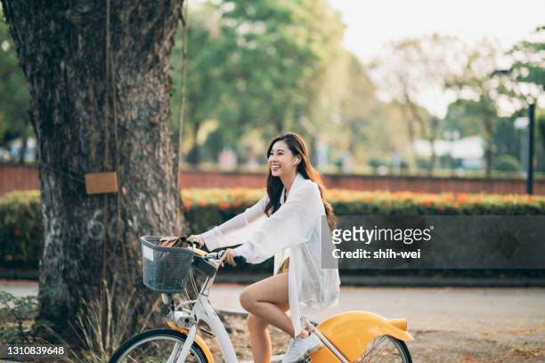 ung asiatisk kvinna som cyklar utomhus - kombinerad mobilitet bildbanksfoton och bilder