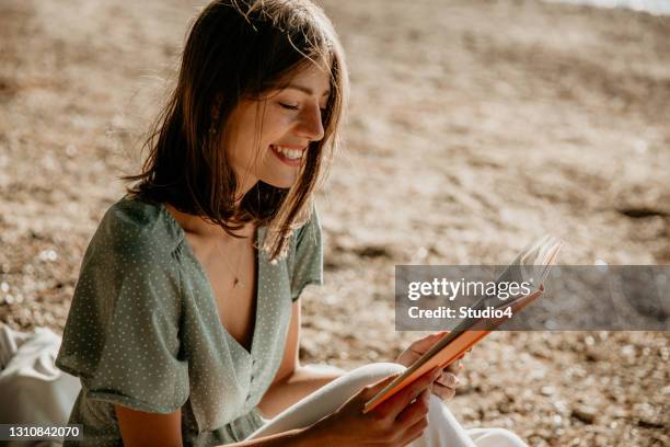 mi tiempo en la naturaleza - mujer leyendo libro en el parque fotografías e imágenes de stock