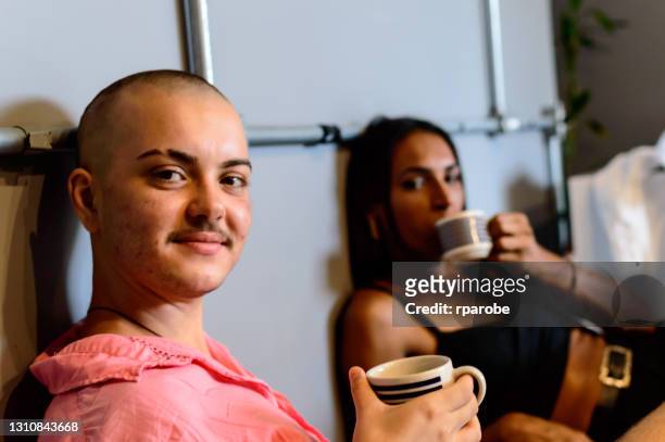 A portrait of a couple / friend, transgender and non-binary, having coffee at home