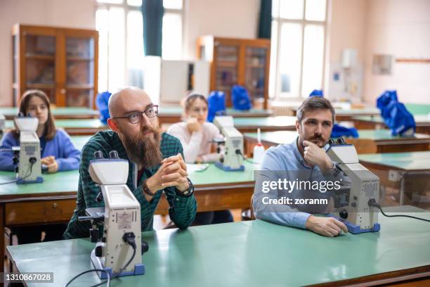 groep niet-traditionele studenten die in universitaire wetenschapsklas zitten en naar lezing luisteren - avondschool stockfoto's en -beelden
