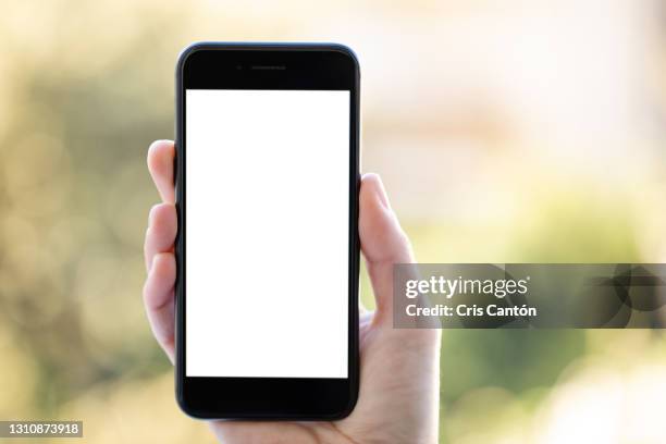 female hand using smartphone with white screen outdoors - smartphone hand ストックフォトと画像