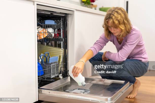 mise d’adolescente utilisant un lave-vaisselle - pastille pour lave vaisselle photos et images de collection