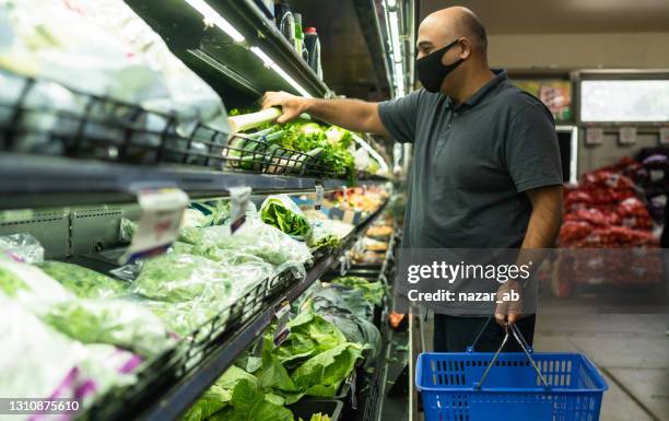mature man buying vegetable with basket in covid-19. - supermarket covid stock pictures, royalty-free photos & images